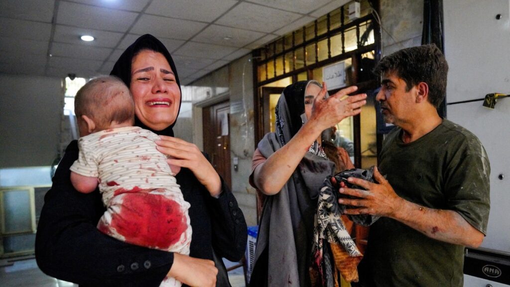 A woman carries her child following the Israeli strikes on Iran in Tehran Iran June 15 2025 reuters